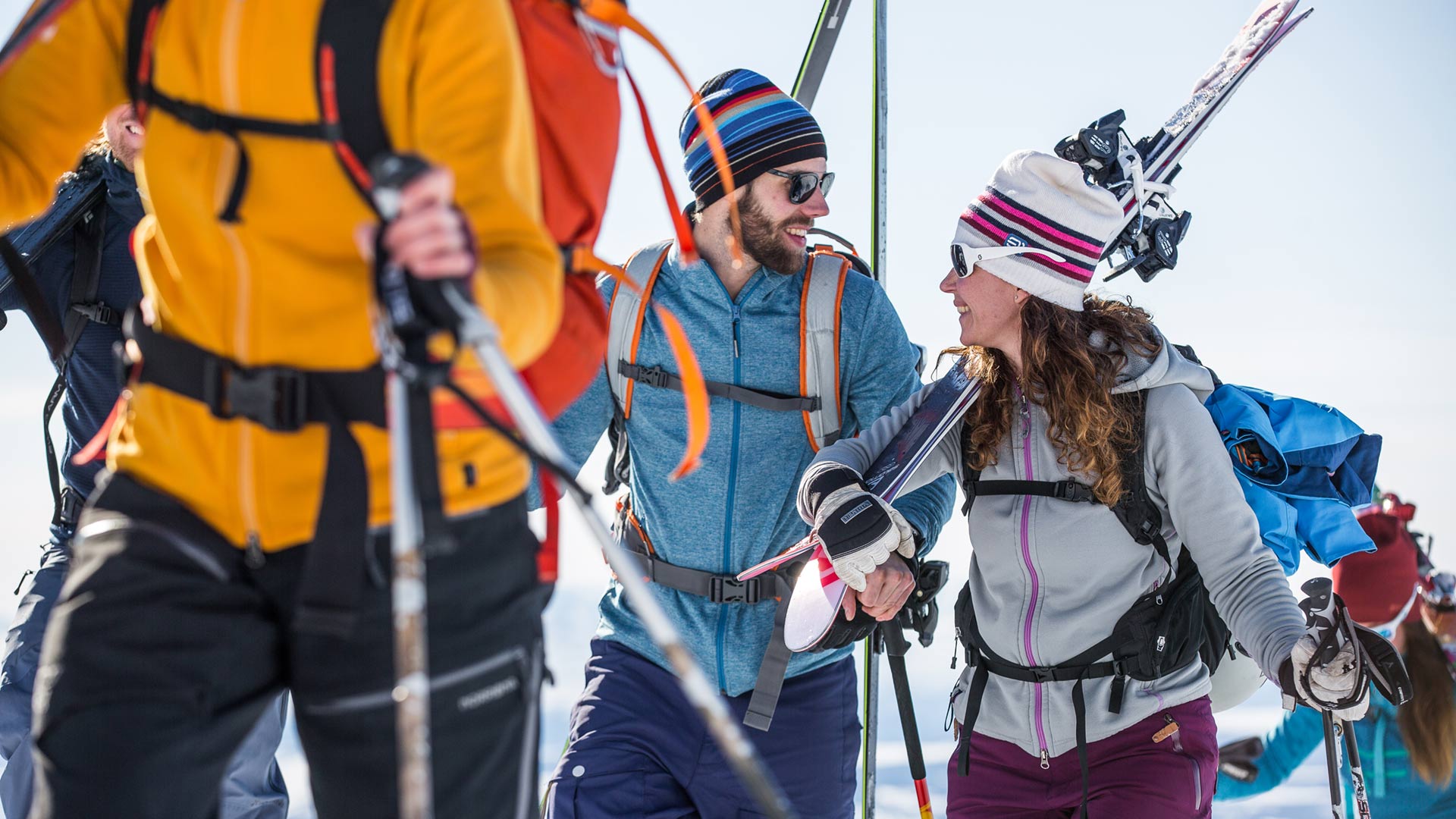 Group of people ski touring looking happy and talking to each other