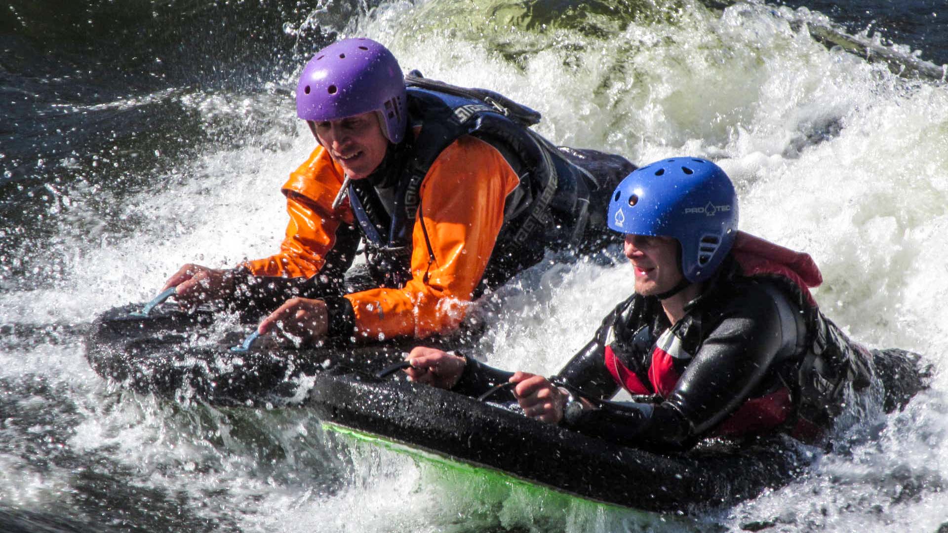 Två personer som kör riverboard
