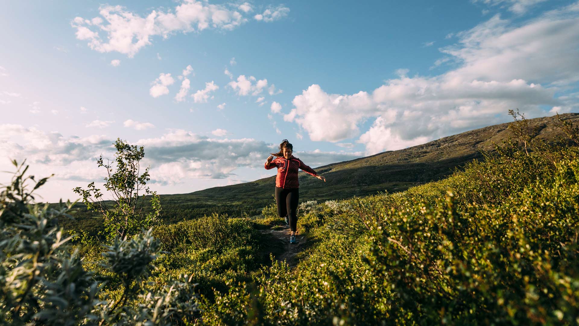 Woman trail running in Åre on a summer day