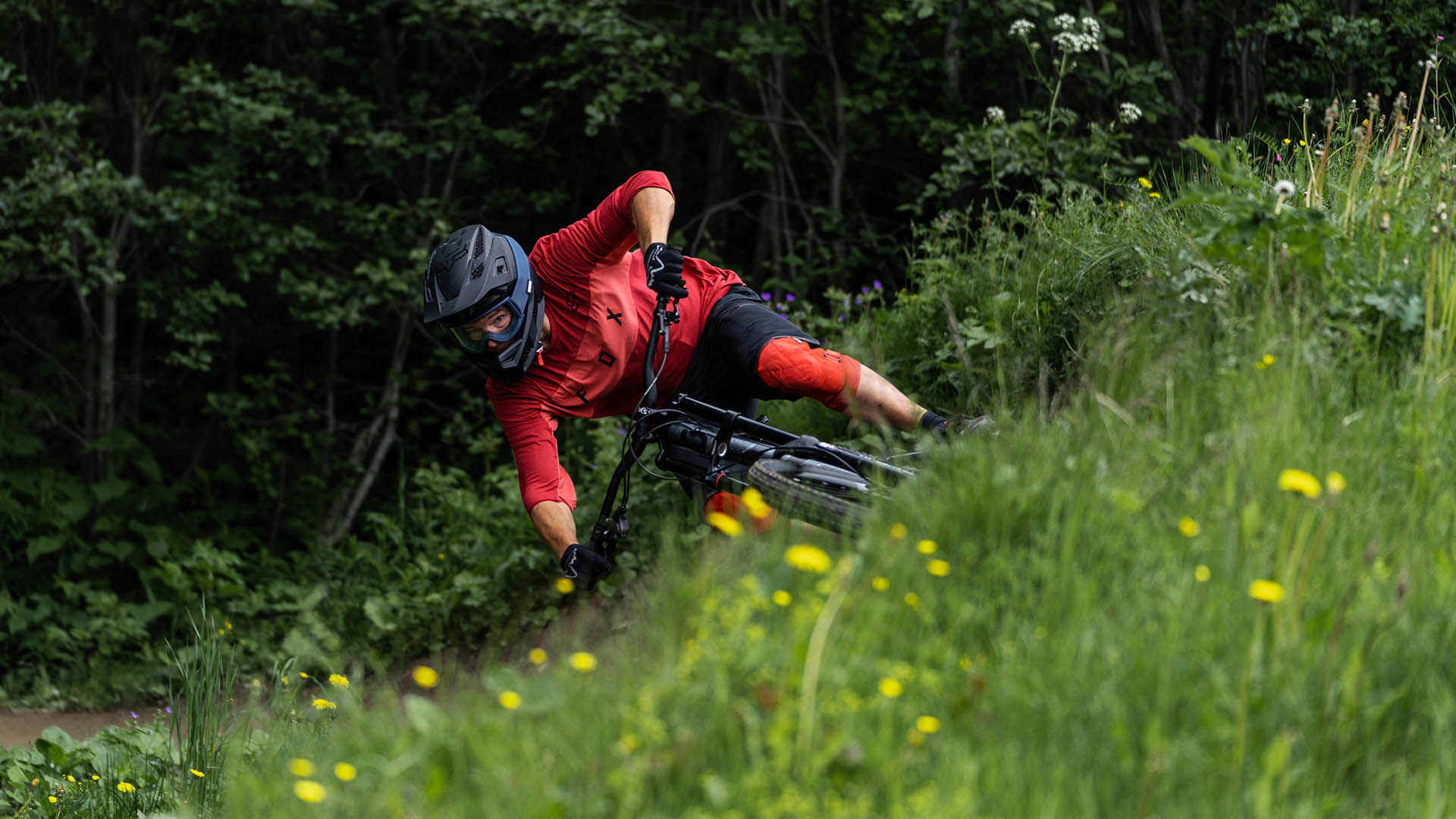 Downhillcyklist i Åre med grönska i förgrunden