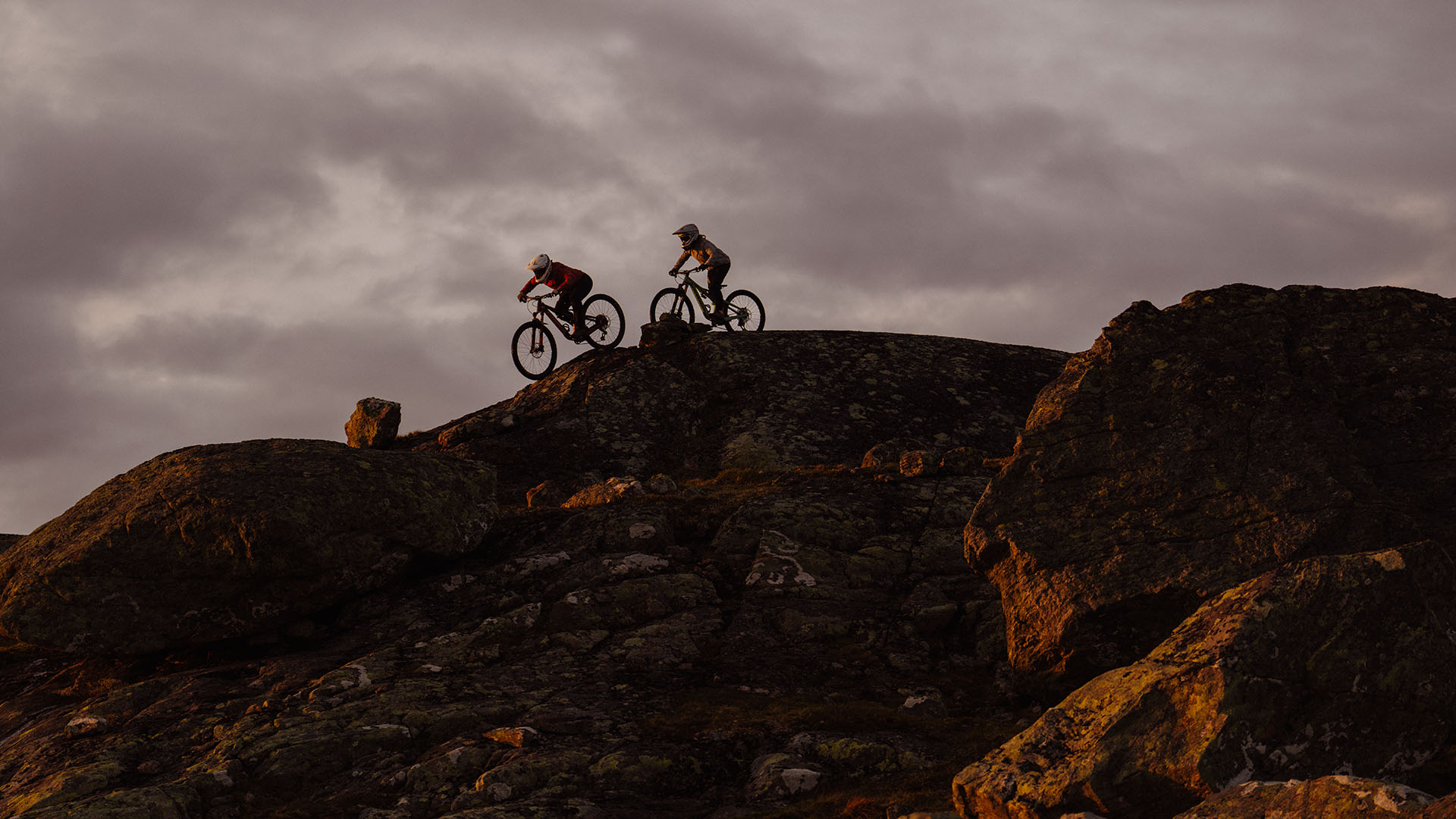 Two cyclists at dusk in Åre Bike Park.