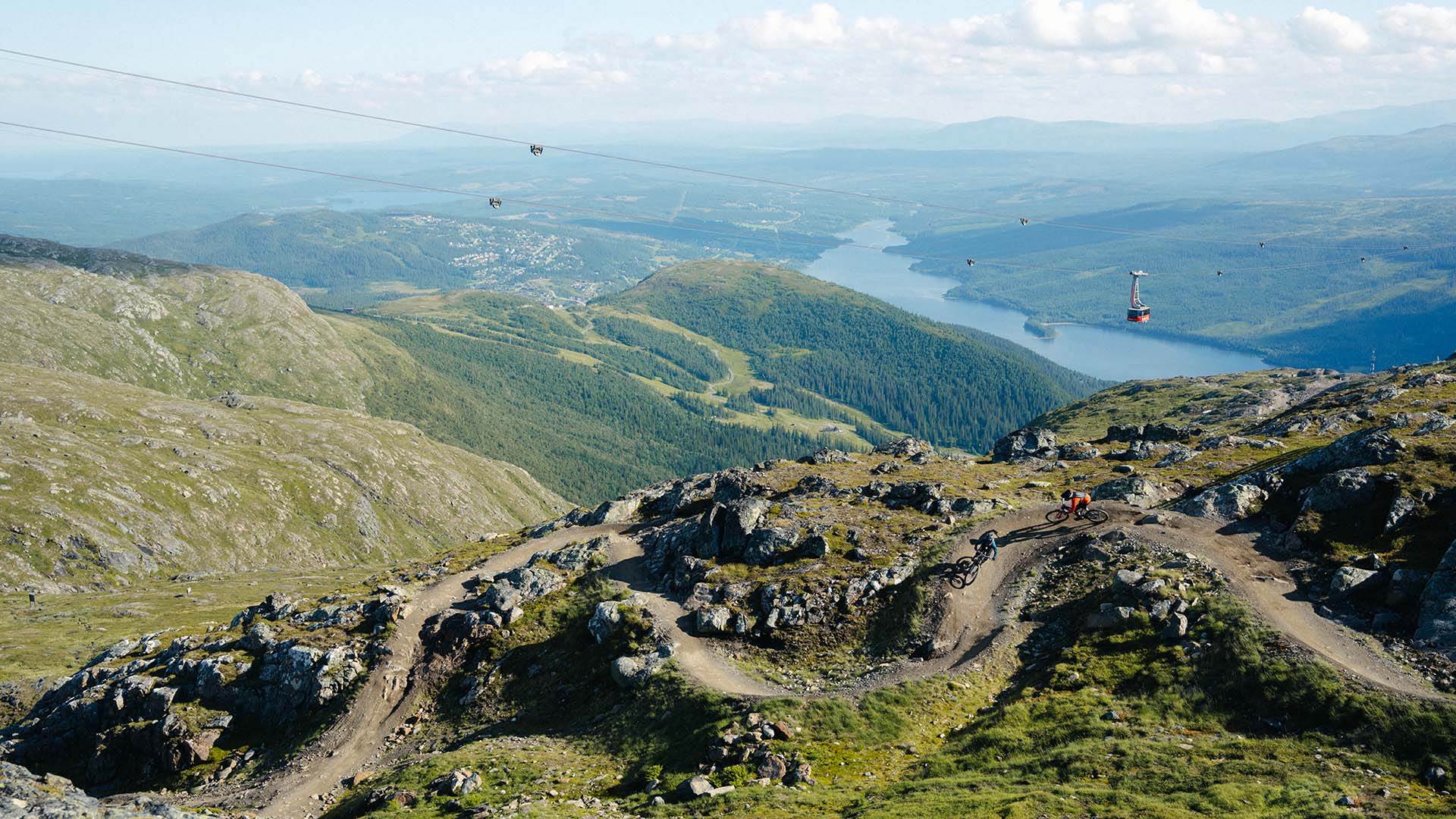 Sommarvy över Åre Bike Park med kabinbanan och Åresjön i bakgrunden