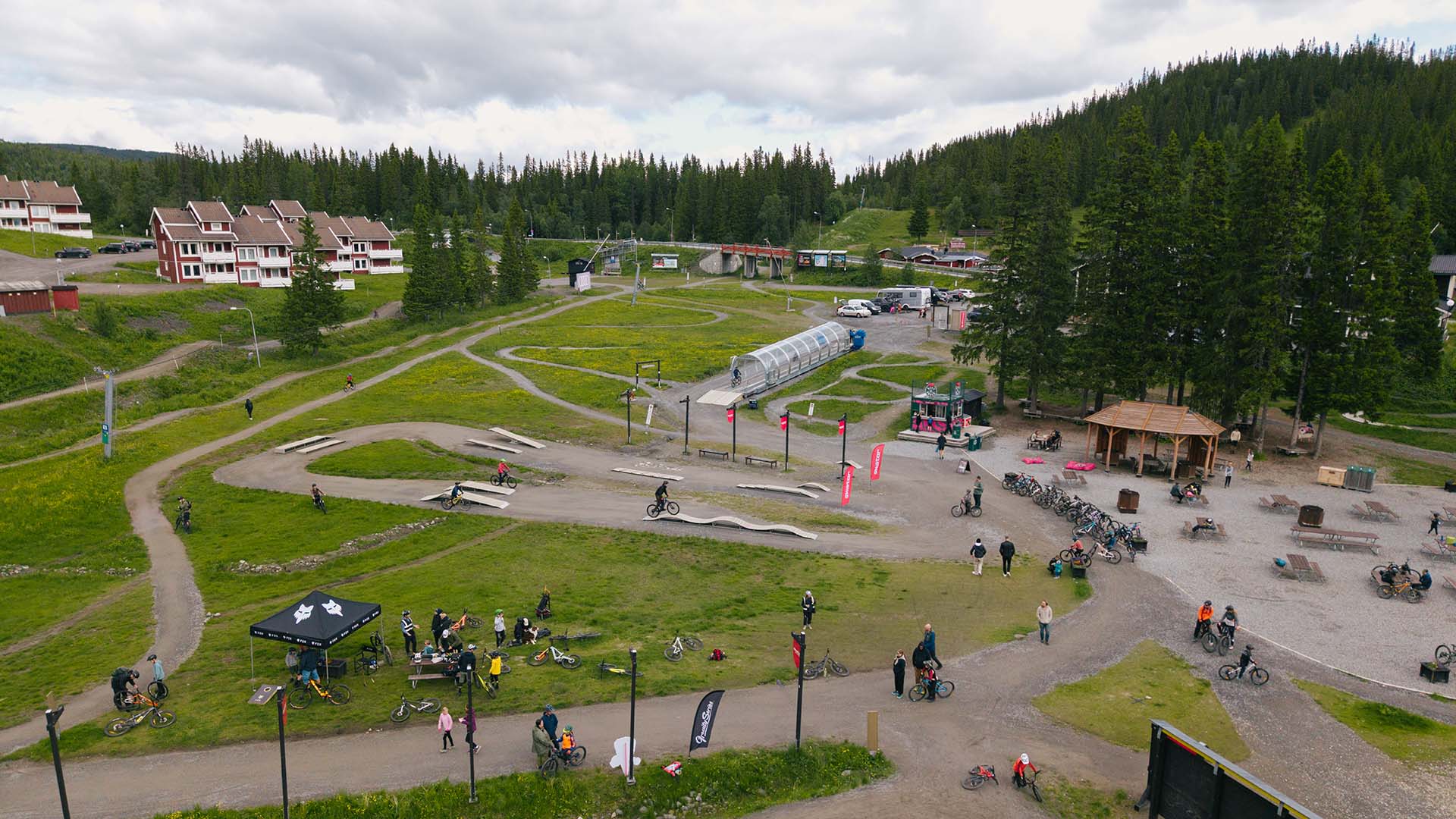 Barnens teknikområde i Åre Bike Park i Björnen, fullt med barn och föräldrar som cyklar en sommardag.