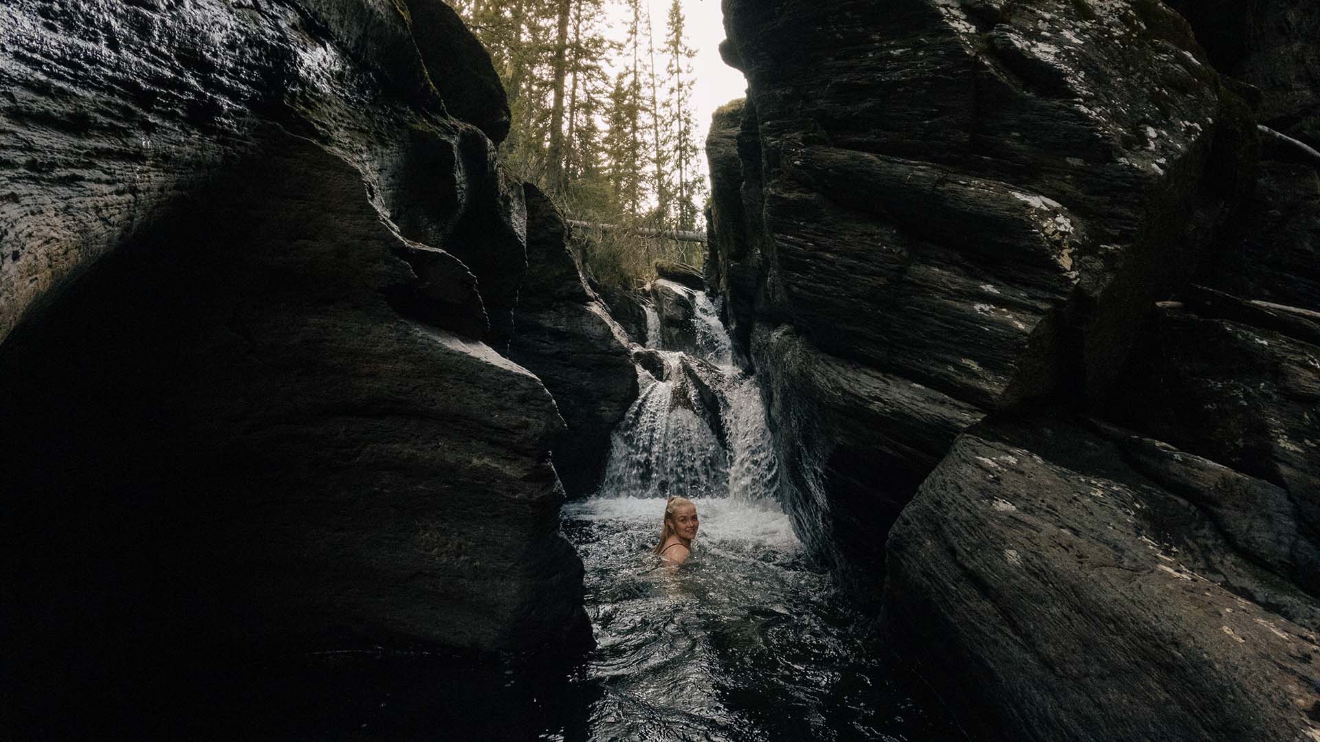 Woman swimming in the natural canyons of Ullån.