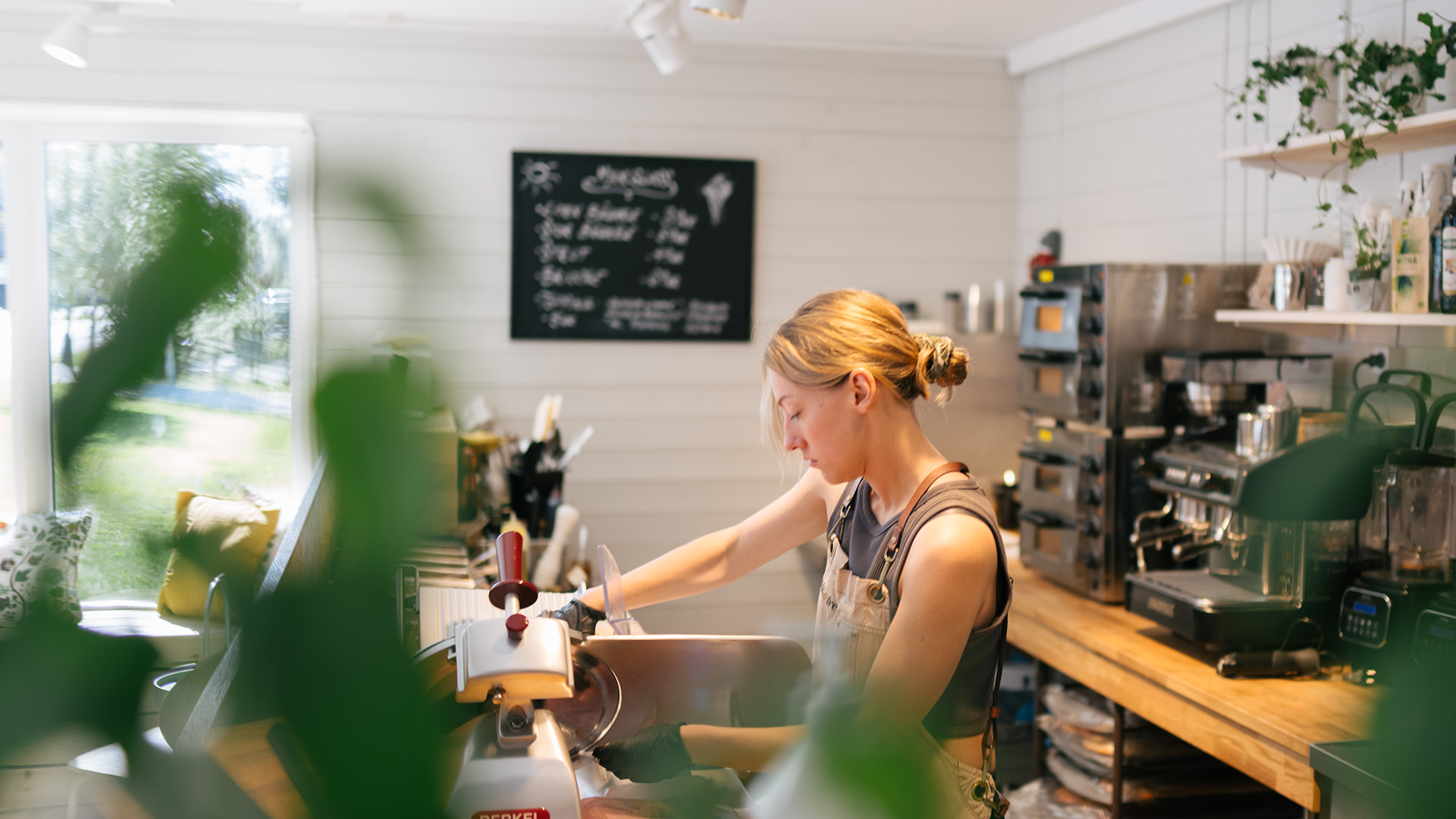 A woman is working behind the desk at a café.