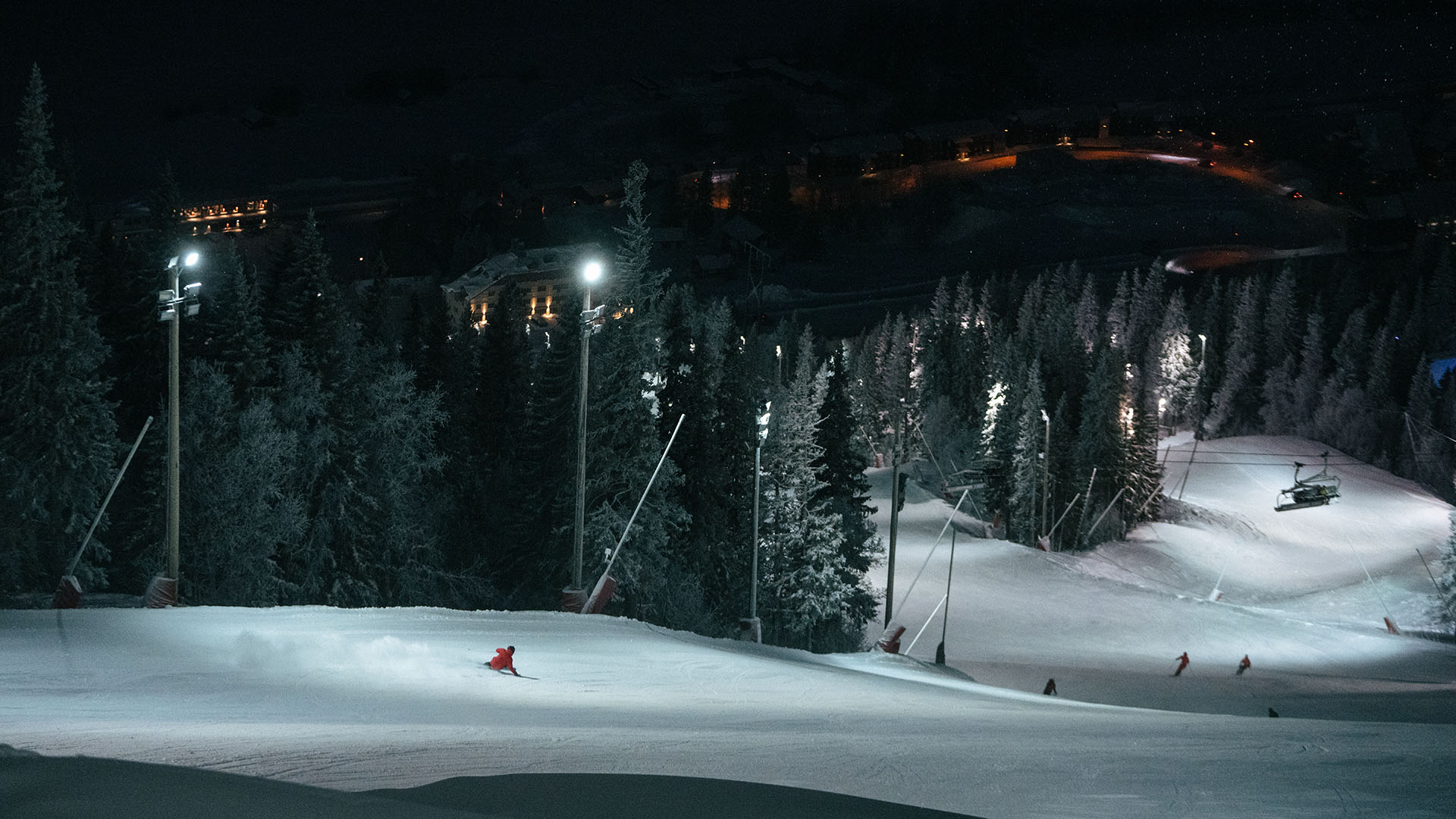 skier goes fast on the fresly groomed and well lit ski slope Gästrappet in the dark