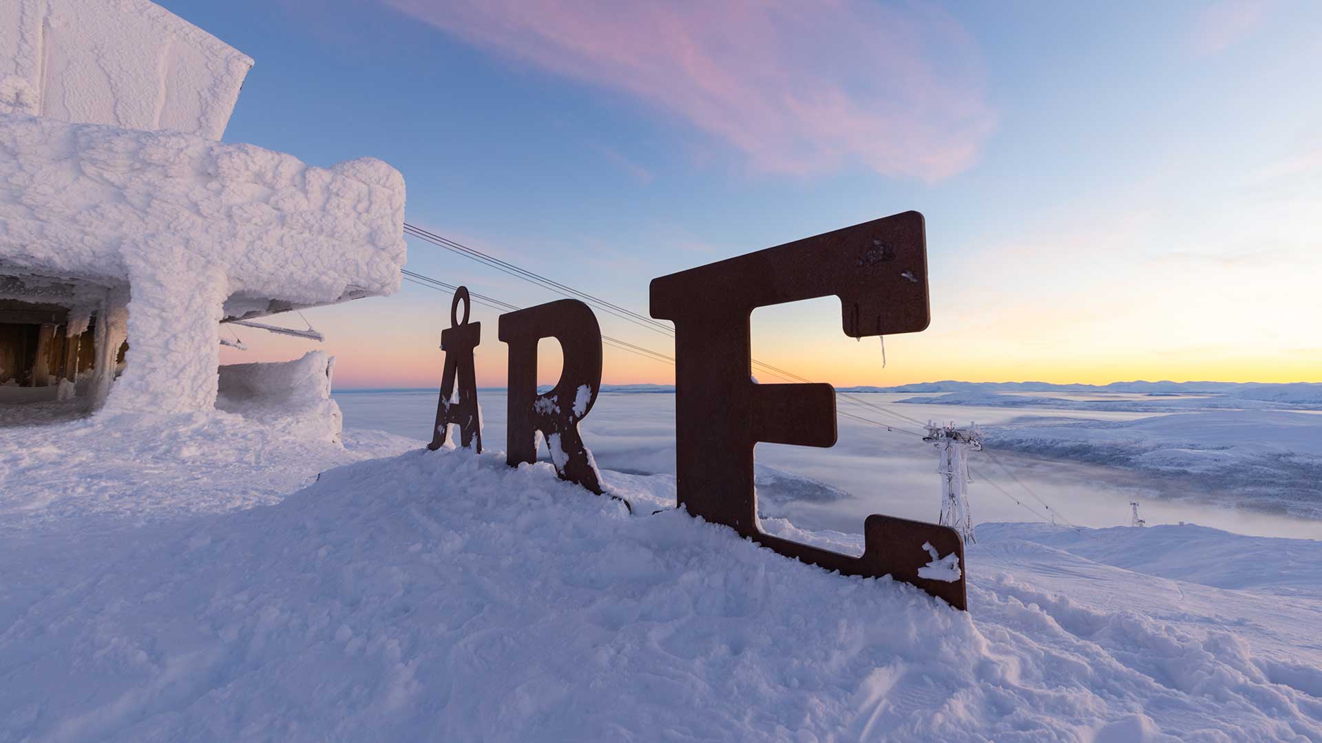 Åre-logo på toppen av åreskutan i soluppgång