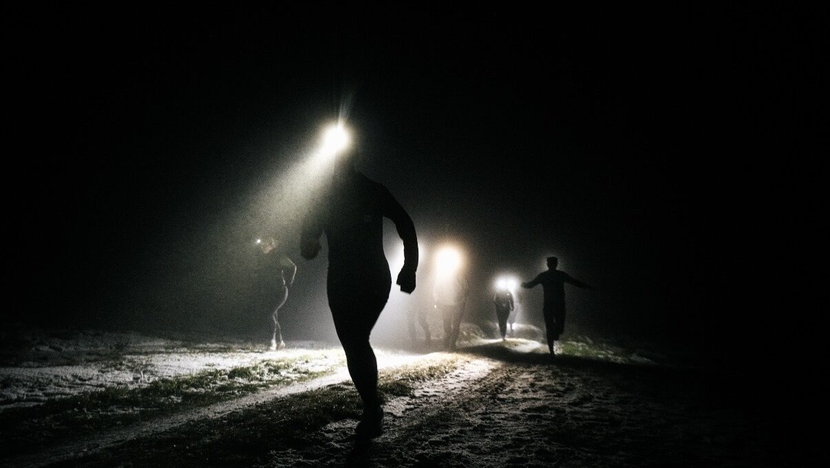 Runners at night with flashlights